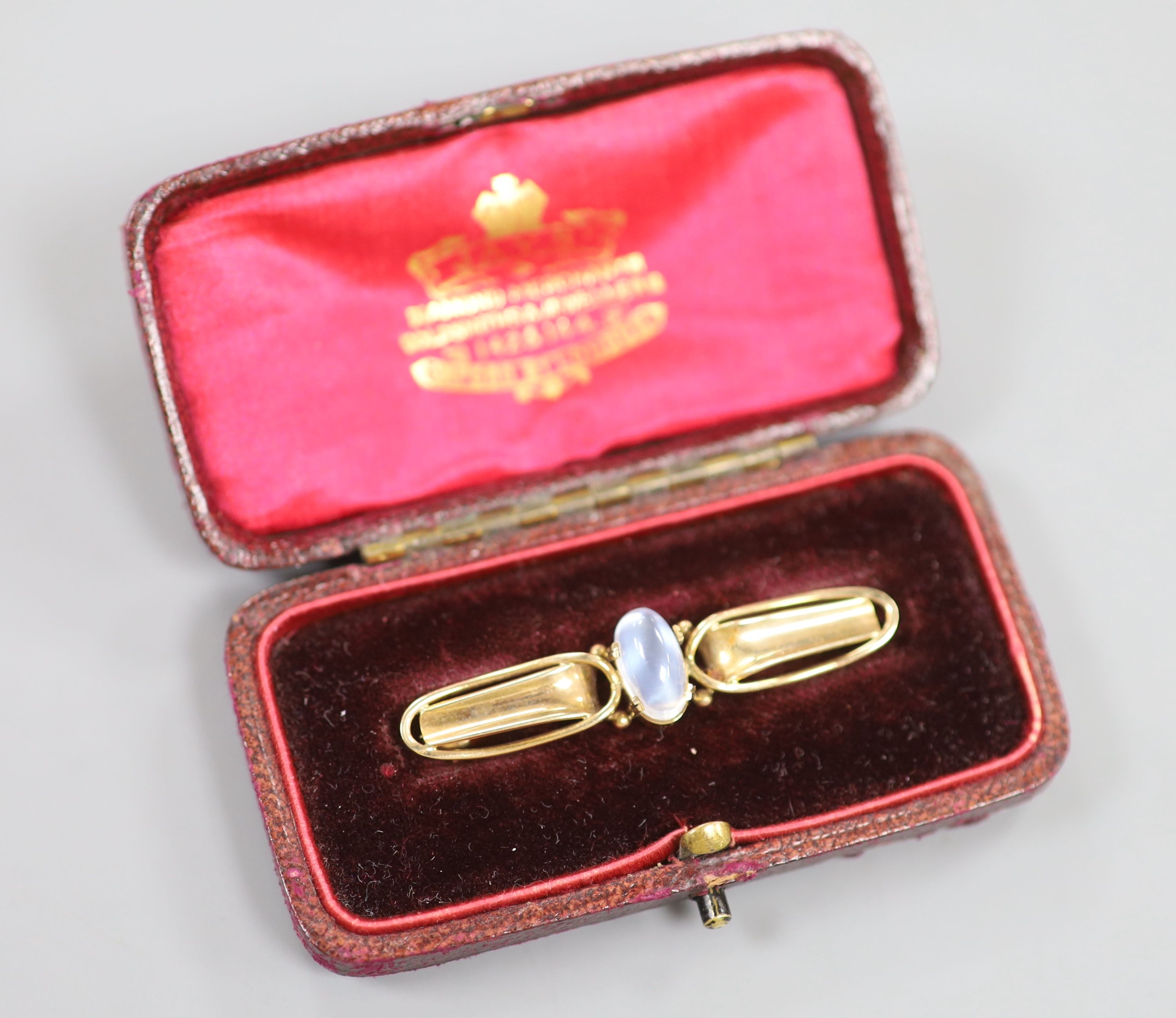 An early 20th century Arts & Crafts 9ct and cabochon moonstone set bar brooch, 47mm, gross weight 3.7 grams.